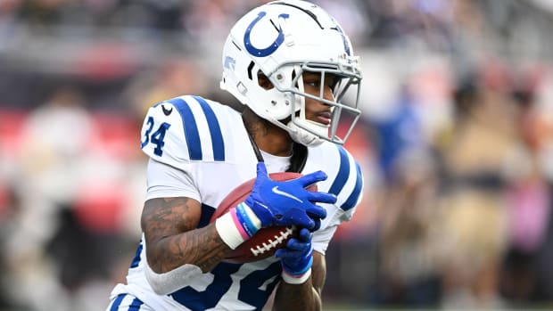 Colts cornerback Isaiah Rodgers carries a ball while returning a punt in a game.